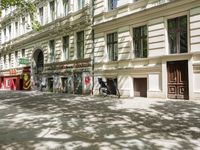 a restaurant in the middle of a narrow city street with graffiti on the wall and the sidewalk outside the building