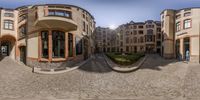 360 - view lens of buildings in the street with green lawn and trees on the ground