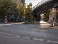 a crosswalk going under a bridge over a road with graffiti on the ground and signs painted on it