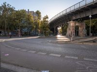 a crosswalk going under a bridge over a road with graffiti on the ground and signs painted on it