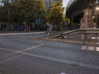 a crosswalk going under a bridge over a road with graffiti on the ground and signs painted on it