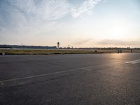 a man flying a kite on top of a large tarmac in an airport setting