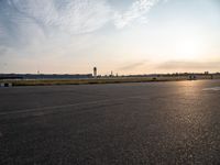 a man flying a kite on top of a large tarmac in an airport setting