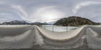 a wide angle lens showing skate boarders moving along the street in front of mountains