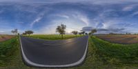 an image of a road going around a bend and through the sky in a fish eye lens