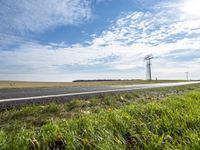 a view of a road that has a pole on it in the distance, with the sky in the background