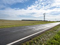 a view of a road that has a pole on it in the distance, with the sky in the background