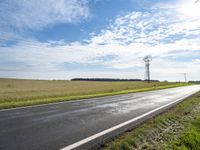 a view of a road that has a pole on it in the distance, with the sky in the background