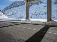 snow - capped mountain viewed from an empty road by a highway with no traffic on it