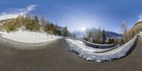 a reflection of mountains in a sphere of photos, with snow covering the ground and the trees surrounding it