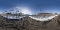 a fish eye lens shows a snow covered mountain scene, and there are snow and trees