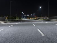 the empty highway is lit up at night time near a stadium or stadium complex with lights