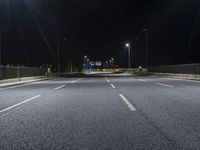 the empty highway is lit up at night time near a stadium or stadium complex with lights