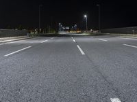 the empty highway is lit up at night time near a stadium or stadium complex with lights