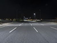 the empty highway is lit up at night time near a stadium or stadium complex with lights