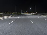 the empty highway is lit up at night time near a stadium or stadium complex with lights