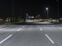 the empty highway is lit up at night time near a stadium or stadium complex with lights