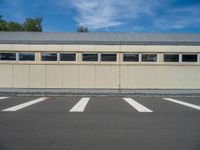 a metal building with a corrugated door in front of it and trees lining the street behind it