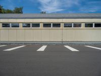 a metal building with a corrugated door in front of it and trees lining the street behind it