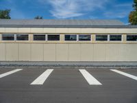 a metal building with a corrugated door in front of it and trees lining the street behind it