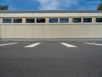 a metal building with a corrugated door in front of it and trees lining the street behind it