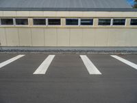 a metal building with a corrugated door in front of it and trees lining the street behind it