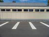 a metal building with a corrugated door in front of it and trees lining the street behind it