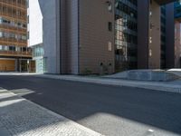 a road through which is a large modern building with an awning over it's entrance