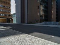 a road through which is a large modern building with an awning over it's entrance