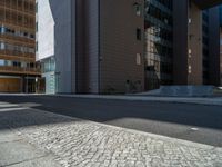 a road through which is a large modern building with an awning over it's entrance