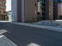 a road through which is a large modern building with an awning over it's entrance