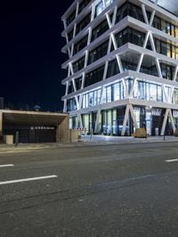 the city building has an unusual pattern that appears to be made out of glass in front of the street