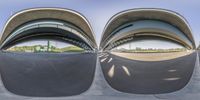 multiple arched buildings reflected in the mirror of a skateboard ramp platform in urban setting