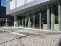 the reflection of people on the window glass is in the building entrance of a glass and steel building