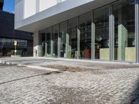 the reflection of people on the window glass is in the building entrance of a glass and steel building