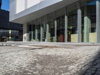 the reflection of people on the window glass is in the building entrance of a glass and steel building