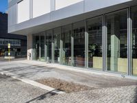 the reflection of people on the window glass is in the building entrance of a glass and steel building