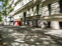 a restaurant in the middle of a narrow city street with graffiti on the wall and the sidewalk outside the building