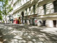 a restaurant in the middle of a narrow city street with graffiti on the wall and the sidewalk outside the building