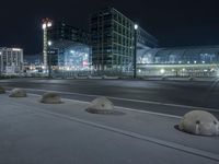 a couple of concrete balls are lined up on the side of the road near a busy intersection
