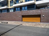 the exterior of a modern residential apartment building with a yellow garage door on the front