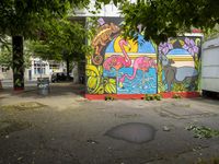 colorful painting on the side of a pole near trees and cars parked along it in front of a building in berlin, germany