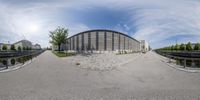 this image shows the 360 - eye view of the building next to the road and on the way there's a bicycle path that is a stone pathway leading to it