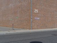 an old brick building sits along a sidewalk with an arrow on the wall of it