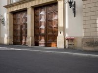 a parking meter on a street in front of doors and a building in the background