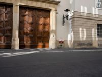 a parking meter on a street in front of doors and a building in the background