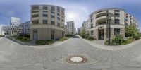 a fish - eye lens with a picture of an outside place with two buildings in the background