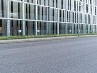 an empty city street is lined with tall office buildings on the opposite side of the road