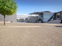 brick paving in front of an open, modern building with a triangular roof area on it