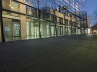 the ground is made of concrete in front of large windows in a building with glass walls